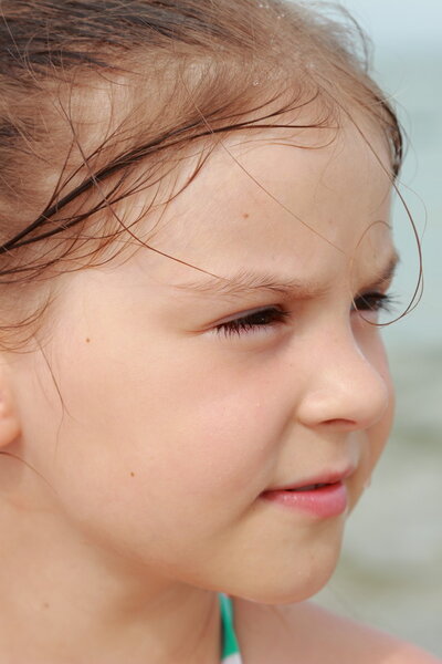 Happy cute little girl in a bright swimsuit play and have fun at the beach on holiday and summer vacation