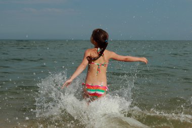 Spor veya yaz tatillerini konulu bir yaz gününde denizde Yüzme bir mayo güzel neşeli genç kız