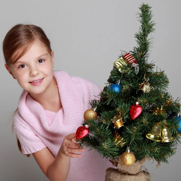 Bir Noel ağacı yakınındaki gülümseyen kız — Stok fotoğraf