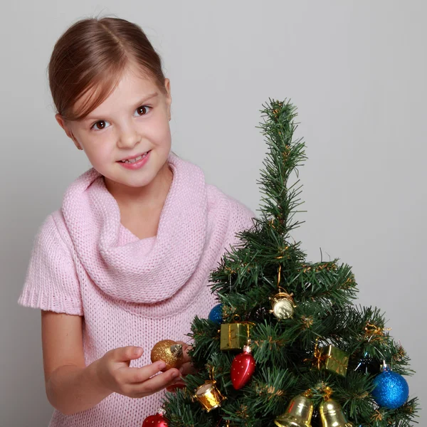 Kind in de buurt van een versierde kerstboom — Stockfoto