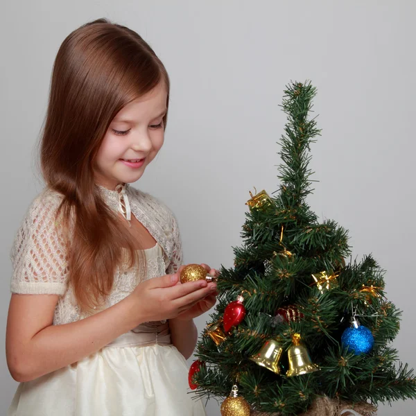 Kind neben einem geschmückten Weihnachtsbaum — Stockfoto