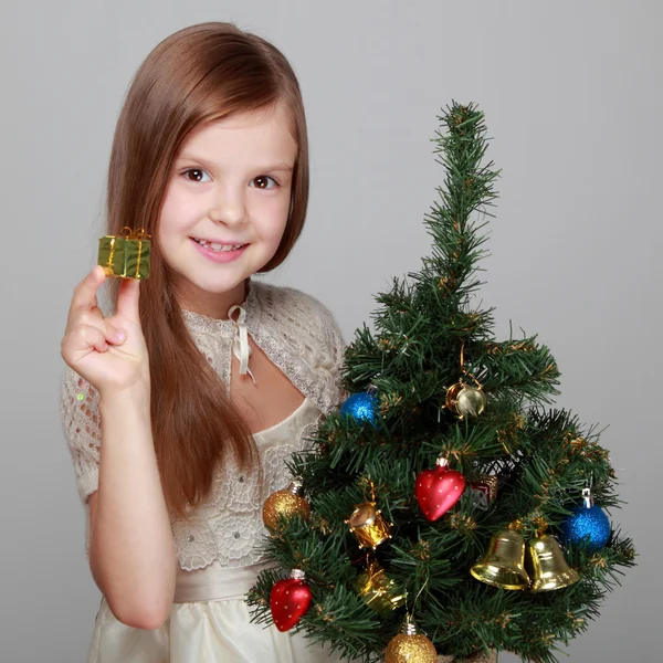 Kind neben einem geschmückten Weihnachtsbaum — Stockfoto