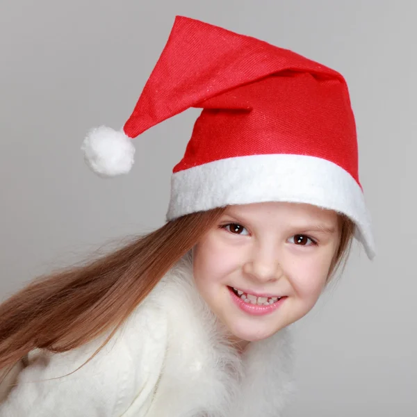 快乐的笑脸肖像在圣诞老人的帽子的小女孩 — 图库照片