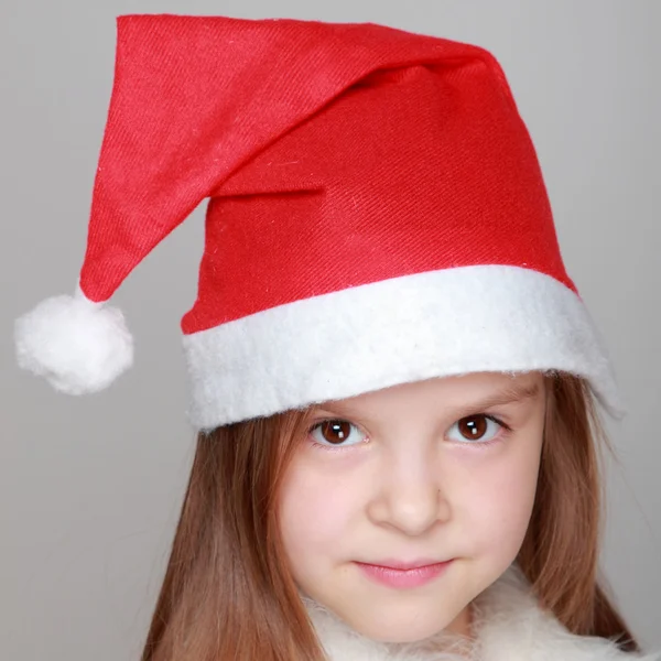 Porträt eines glücklichen kleinen Smiley-Mädchens mit Weihnachtsmütze — Stockfoto