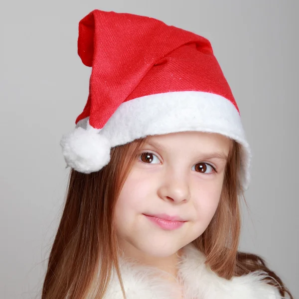 Porträtt av glad smiley liten flicka i Santa hatt — Stockfoto