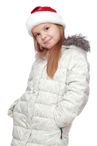 一个开朗的女孩，与圣诞老人的帽子的肖像 — 图库照片
