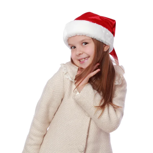Criança encantadora em um chapéu de Papai Noel é feliz e ri — Fotografia de Stock
