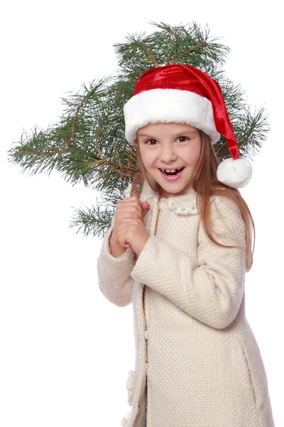 Chica joven positiva en el sombrero de Santa es feliz y riendo con el árbol de Navidad —  Fotos de Stock