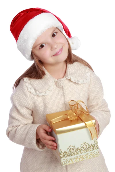 Bella sorridente bambina con il cappello rosso di Babbo Natale che tiene la scatola di Natale — Foto Stock