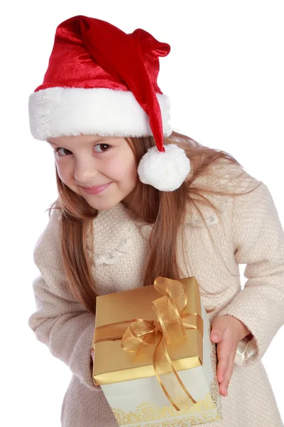 Pretty smiling little girl in Santa's red hat holding Christmas box — Stock Photo, Image