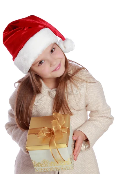 Jolie petite fille souriante dans le chapeau rouge du Père Noël tenant boîte de Noël — Photo