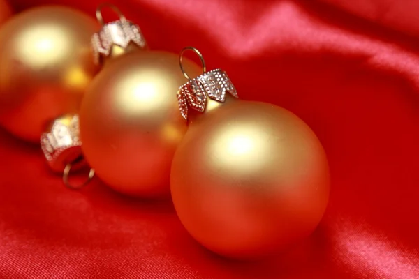 Bolas de vidrio de Navidad sobre fondo de seda roja — Foto de Stock