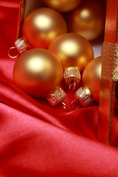 Weihnachtsglaskugeln über rotem Seidenhintergrund — Stockfoto
