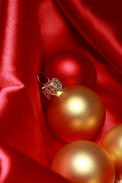 Christmas glass balls over red silk background — Stock Photo, Image