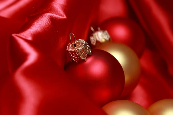 Christmas glass balls over red silk background — Stock Photo, Image