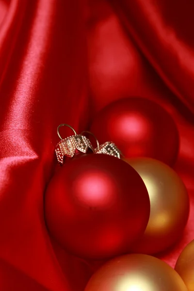 Χριστούγεννα μπάλες γυαλί πάνω από κόκκινο μετάξι φόντο — Φωτογραφία Αρχείου