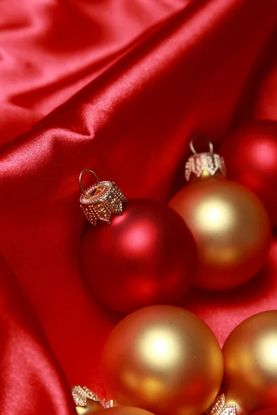 Christmas glass balls over red silk background — Stock Photo, Image