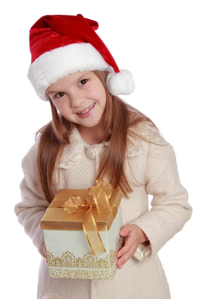 Pretty smiling little girl in Santa's red hat holding Christmas box Stock Image