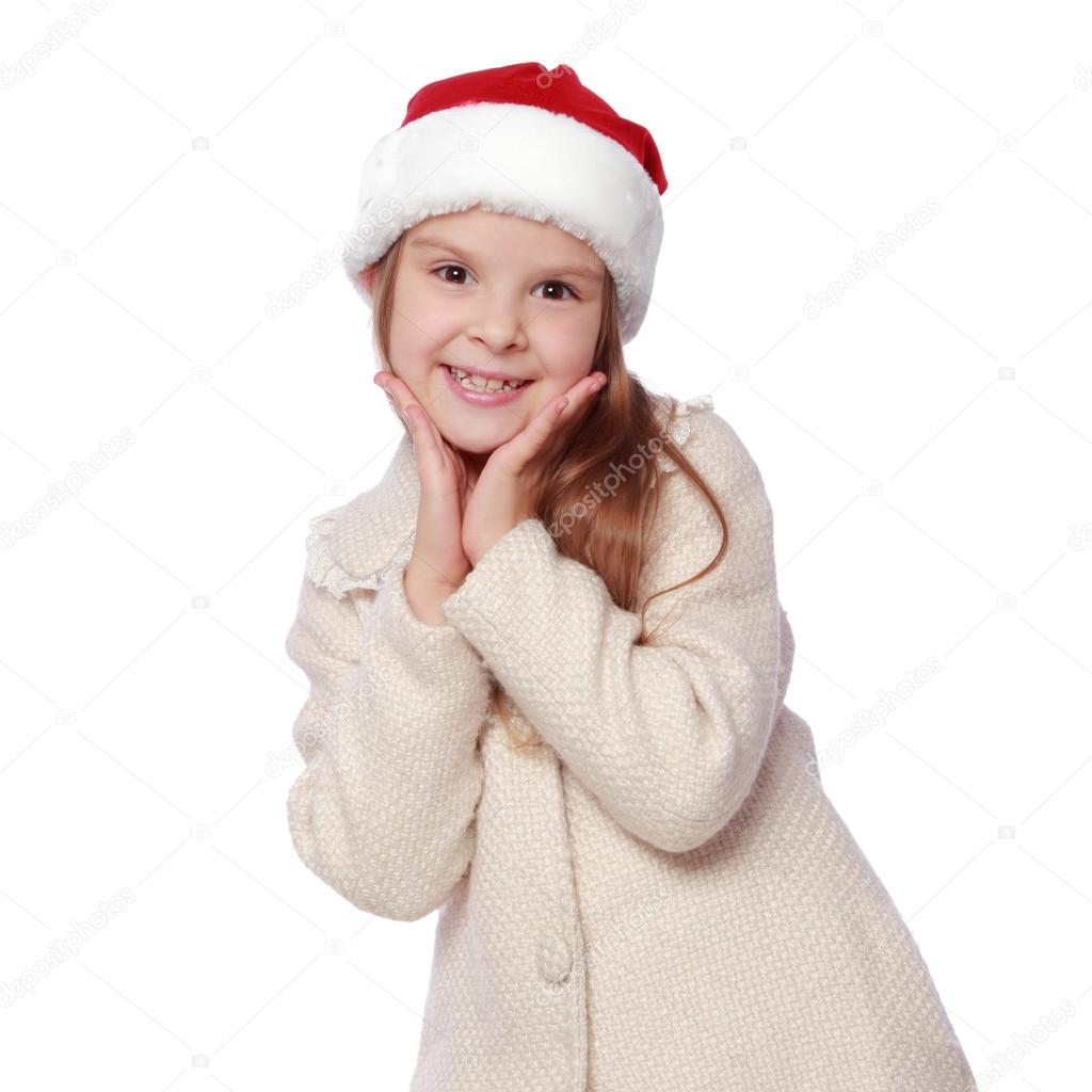 Lovely child in a Santa hat is happy and laughs