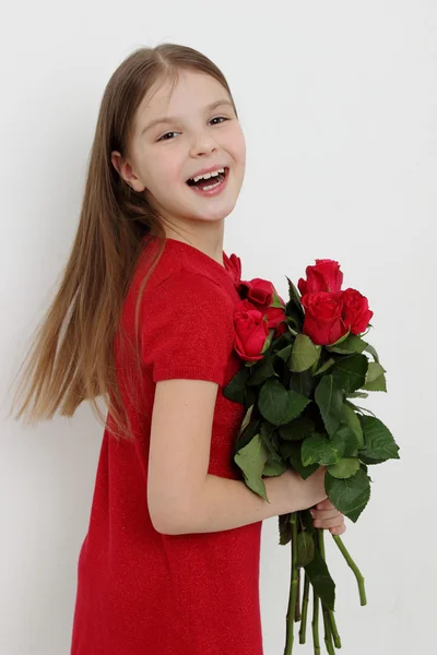 Junges Mädchen und rote Rosen — Stockfoto