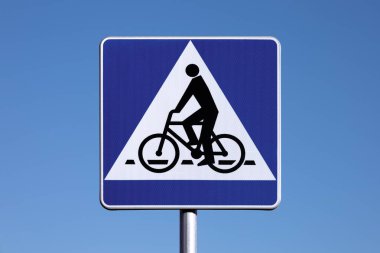 Bisikletçi geçiyor - Mavi arka planda Polonya yol tabelası.