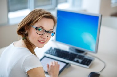 Gülümseyen kız öğrenci / işkadını tablet bilgisayarını kullanarak 