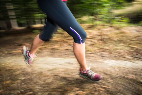 Giovane donna che corre all'aperto in una foresta, andando veloce — Foto Stock