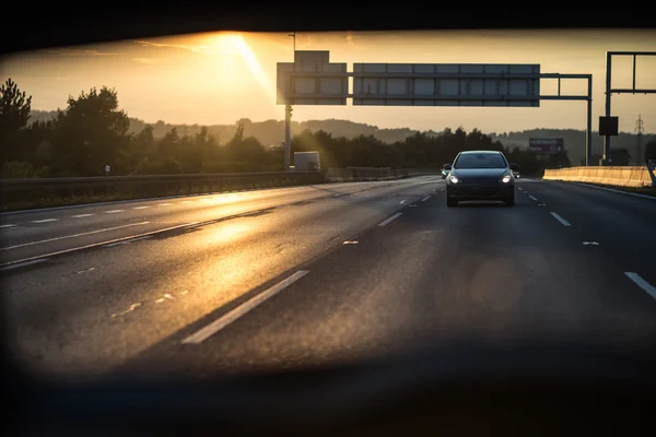 Voitures sur une autoroute au coucher du soleil — Photo