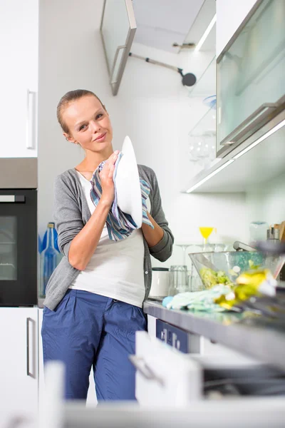 Mujer joven lavando platos en su cocina moderna —  Fotos de Stock