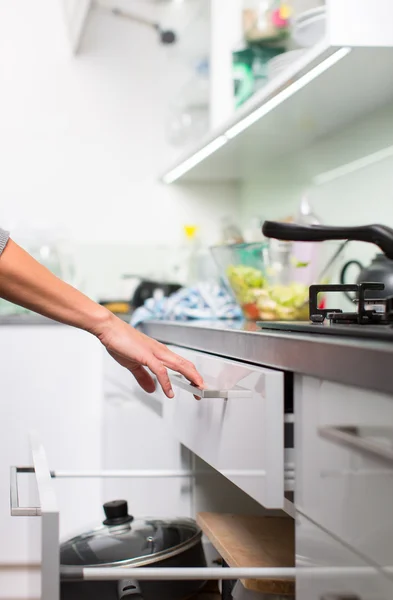 Mujer joven lavando platos en su cocina moderna — Foto de Stock