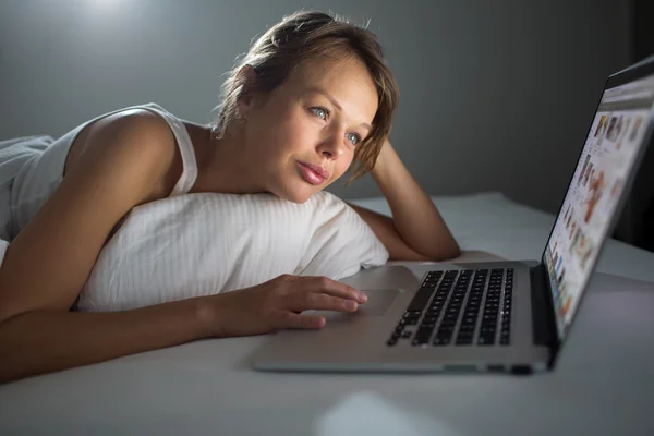 Όμορφη, νεαρή γυναίκα χρησιμοποιώντας το φορητό υπολογιστή στο κρεβάτι — Φωτογραφία Αρχείου
