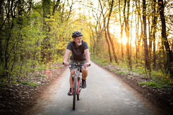 Äldre man på sin mountainbike utomhus — Stockfoto