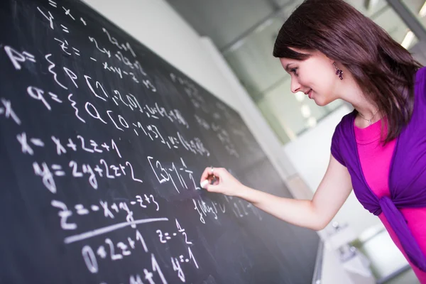 Bonita, joven estudiante universitaria limpiando la pizarra — Foto de Stock