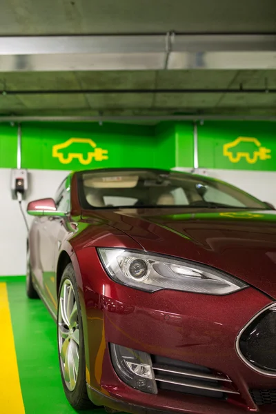 Electric car at a charging point in an underground parking — Stock Photo, Image