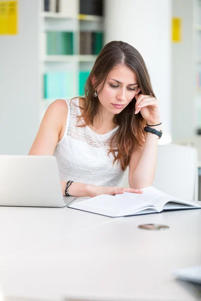 Hübsche junge College-Studentin in einer Bibliothek — Stockfoto