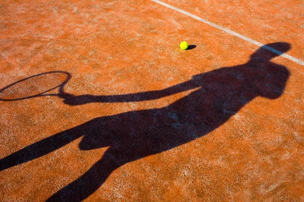 Schatten eines Tennisspielers in Aktion auf einem Tennisplatz — Stockfoto