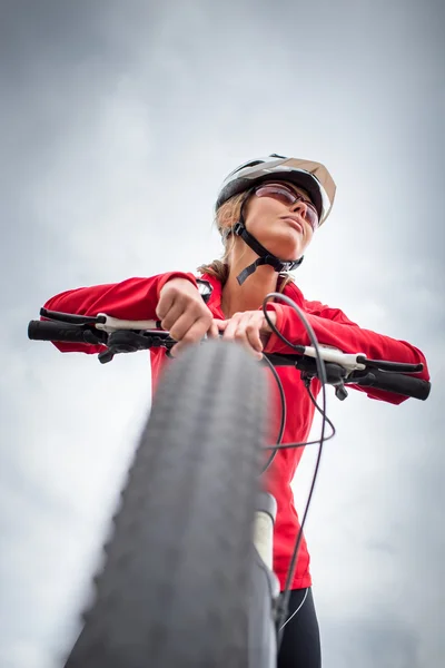 Досить, молода жінка-велосипедистка на відкритому повітрі на своєму гірському велосипеді — стокове фото