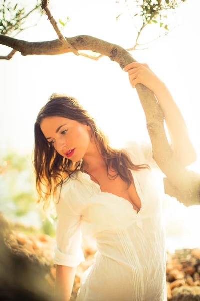 Aantrekkelijke, jonge brunette op het strand, te midden van olijfbomen — Stockfoto