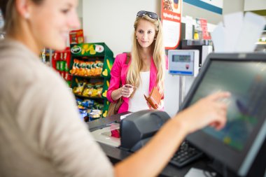 Güzel genç kadın onun bakkal sayaç için ödeme