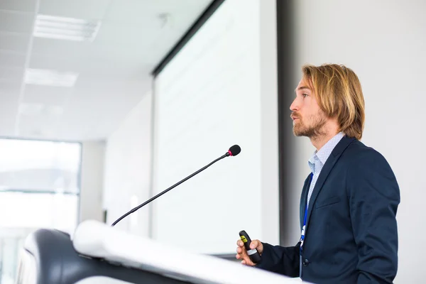 Handsome young man giving a speech at a conference — Stock Photo, Image