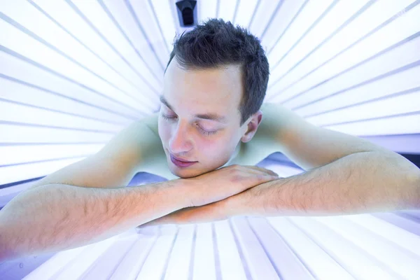 Pohledný mladý muž relaxační během opalování solárium — Stock fotografie
