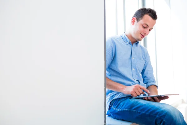 Handsome young man using his tablet computer (color toned image; — Stock Photo, Image