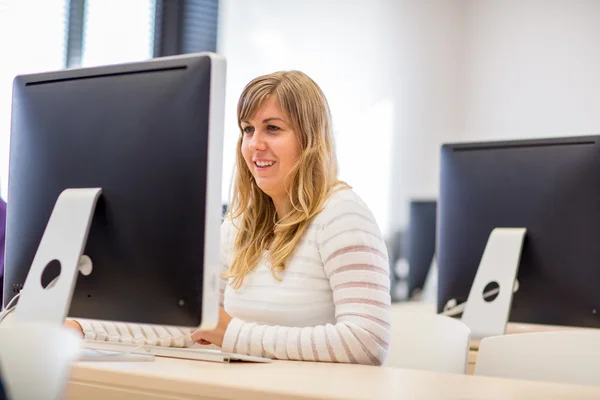 Estudante / mulher de negócios usando um computador desktop — Fotografia de Stock
