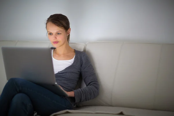 Pretty, young woman using her laptop computer at home — Stock Photo, Image