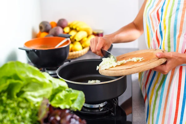 Jovem cozinhando em sua cozinha moderna — Fotografia de Stock