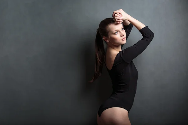 Beautiful, young woman in front of a grey background — Stock Photo, Image