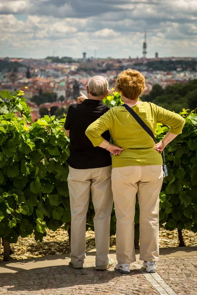 プラハ (プラハの景色を眺めながら高齢者観光客のカップル, — ストック写真