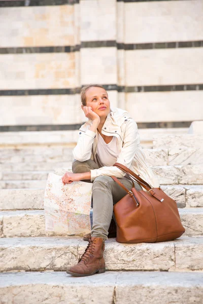 Gorgeous female tourist with a map discovering a foreign city — Stock Photo, Image