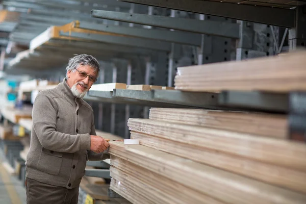 Homem escolhendo e comprando madeira de construção em uma loja diy — Fotografia de Stock