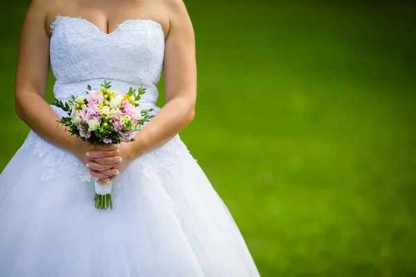 Mooie bruiloft boeket in handen van de bruid — Stockfoto